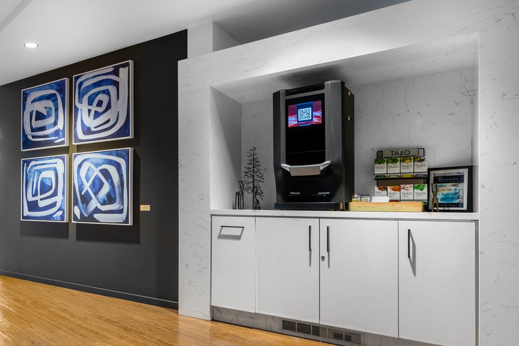 a room with a coffee machine and paintings on the wall