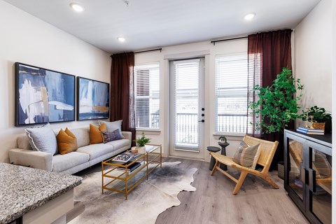 A living room with a couch, a coffee table, and a painting on the wall.