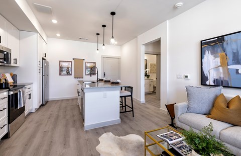 A modern kitchen with a white island and a dining table with chairs.