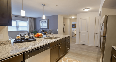 A kitchen with a granite countertop and stainless steel appliances.