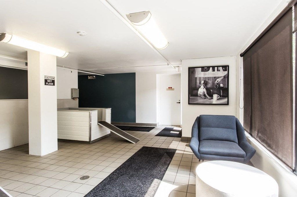 an empty lobby with a blue chair and a reception desk