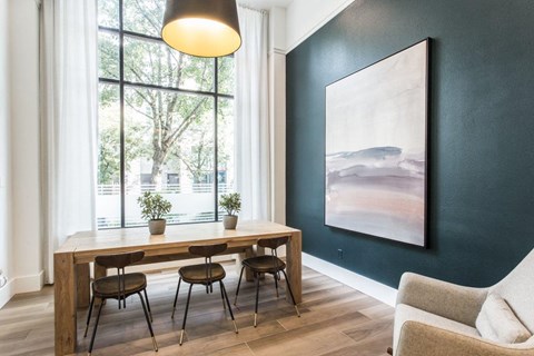 a dining room with a table and chairs and a painting on the wall