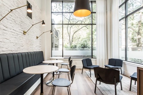 a seating area with tables and chairs and a large window