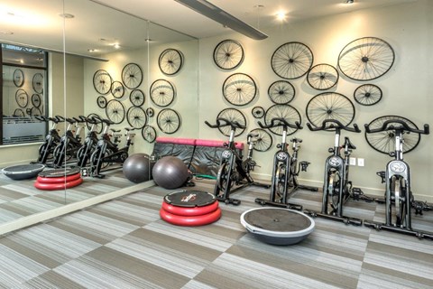 a gym with bikes hanging on the wall