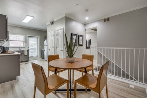 A dining room with a round table and chairs.
