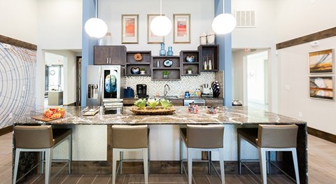 A kitchen with a table and chairs in front of it.