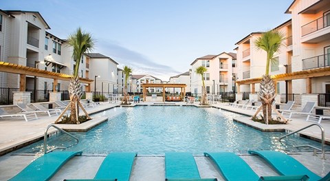 The Flats at Shadowglen Apartments in Manor, TX Pool with Lounge Chairs