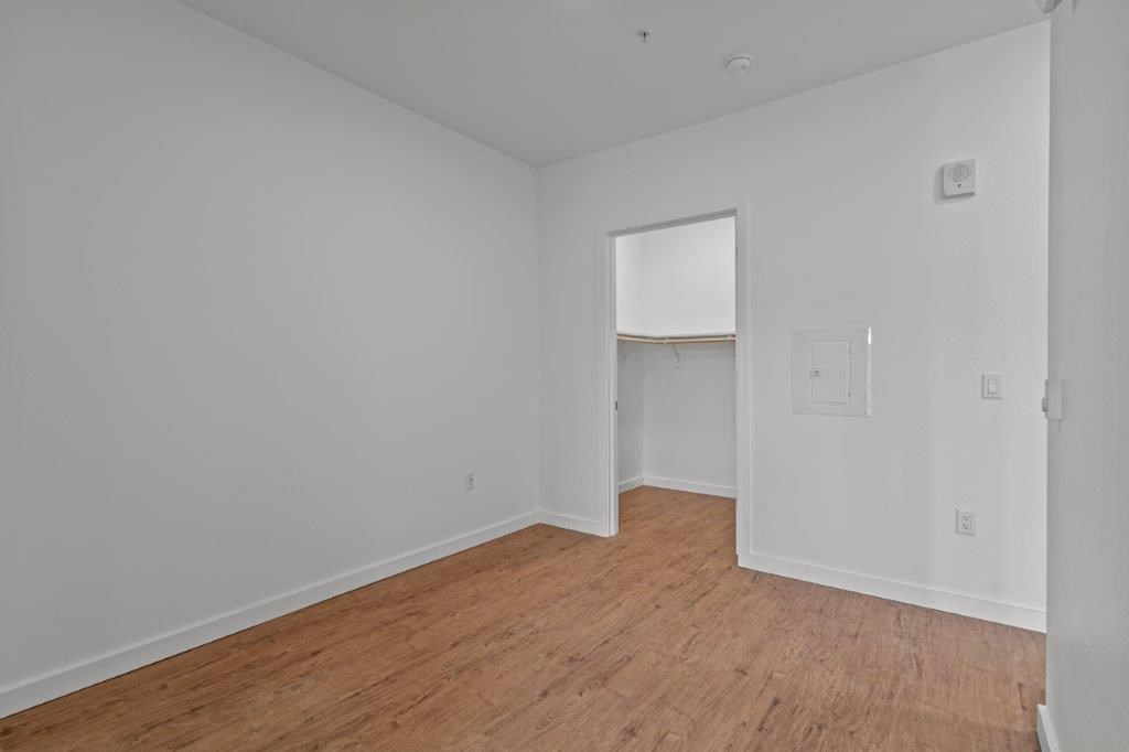 an empty room with a wood floor and white walls