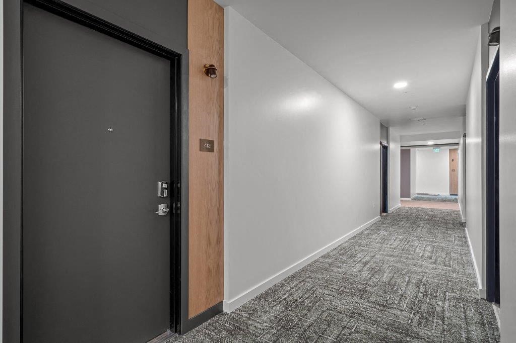 a hallway with a door and a carpeted floor