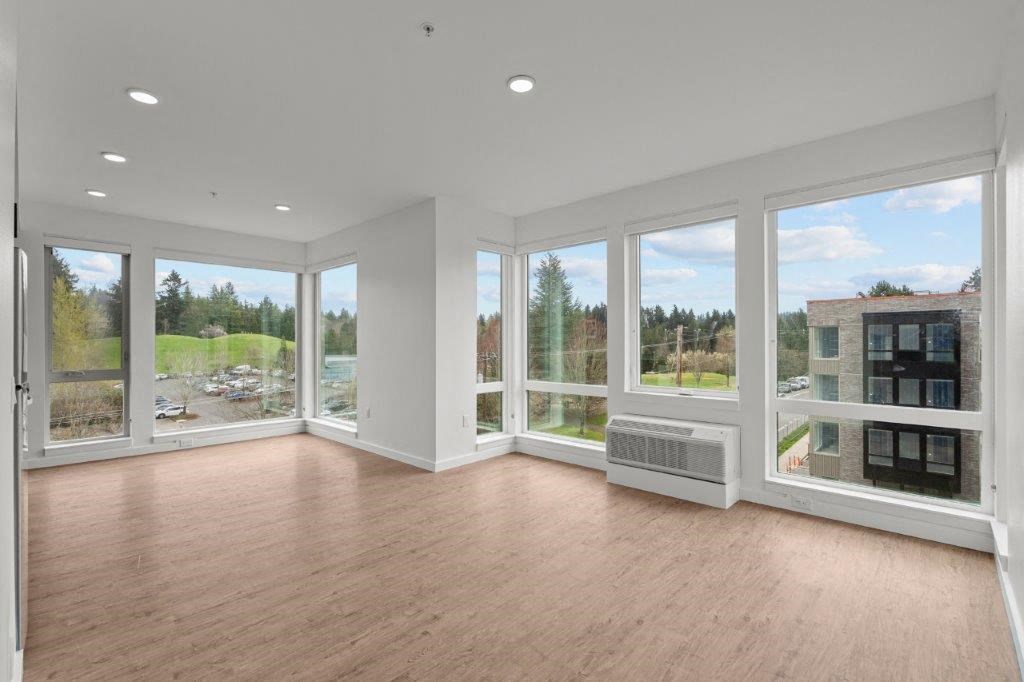 a living room with a lot of windows and a wood floor