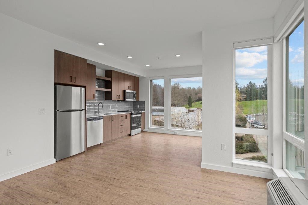 a kitchen with a large window and a stainless steel refrigerator