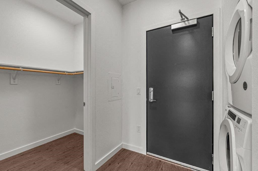 a white laundry room with a black door and a washing machine