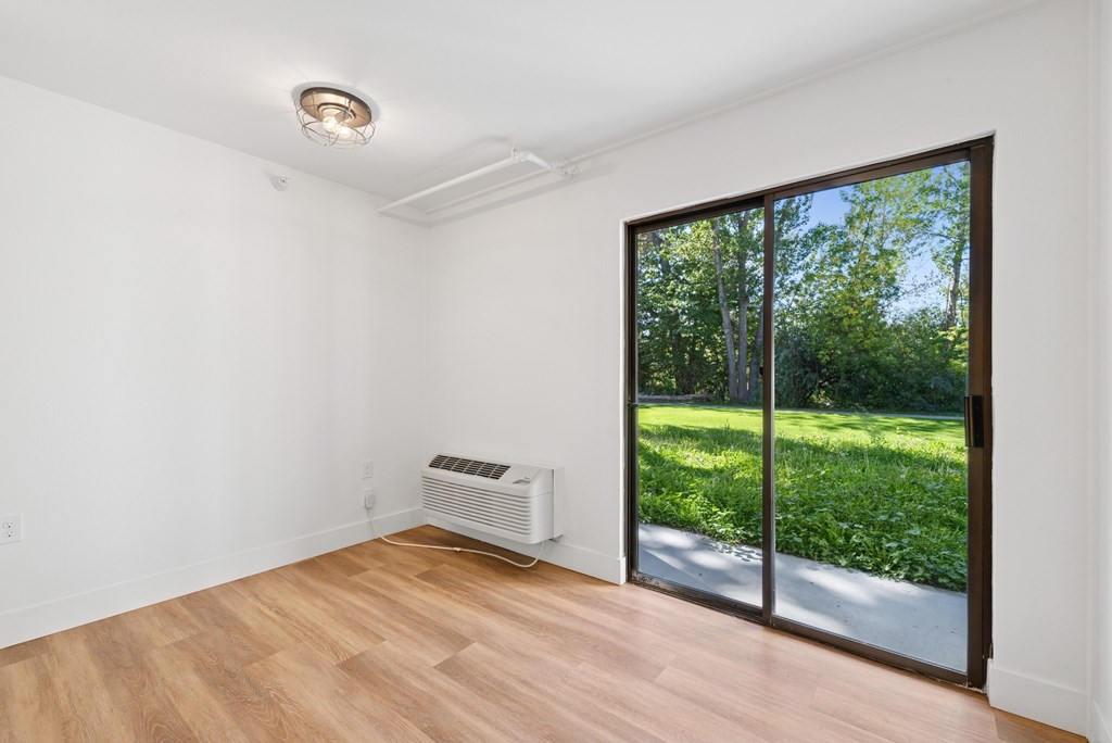 A room with a sliding glass door leading to a garden.