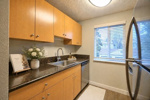 A kitchen with wooden cabinets and a black countertop.