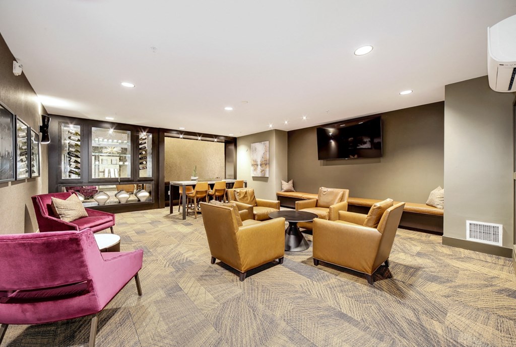 The Hayes on Stone Way Apartments  lounge area with chairs and tables and a television
