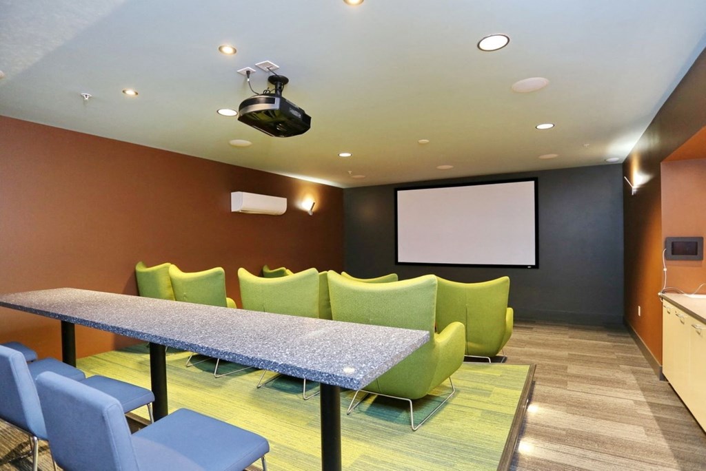 a room with a table and chairs and a projection screen