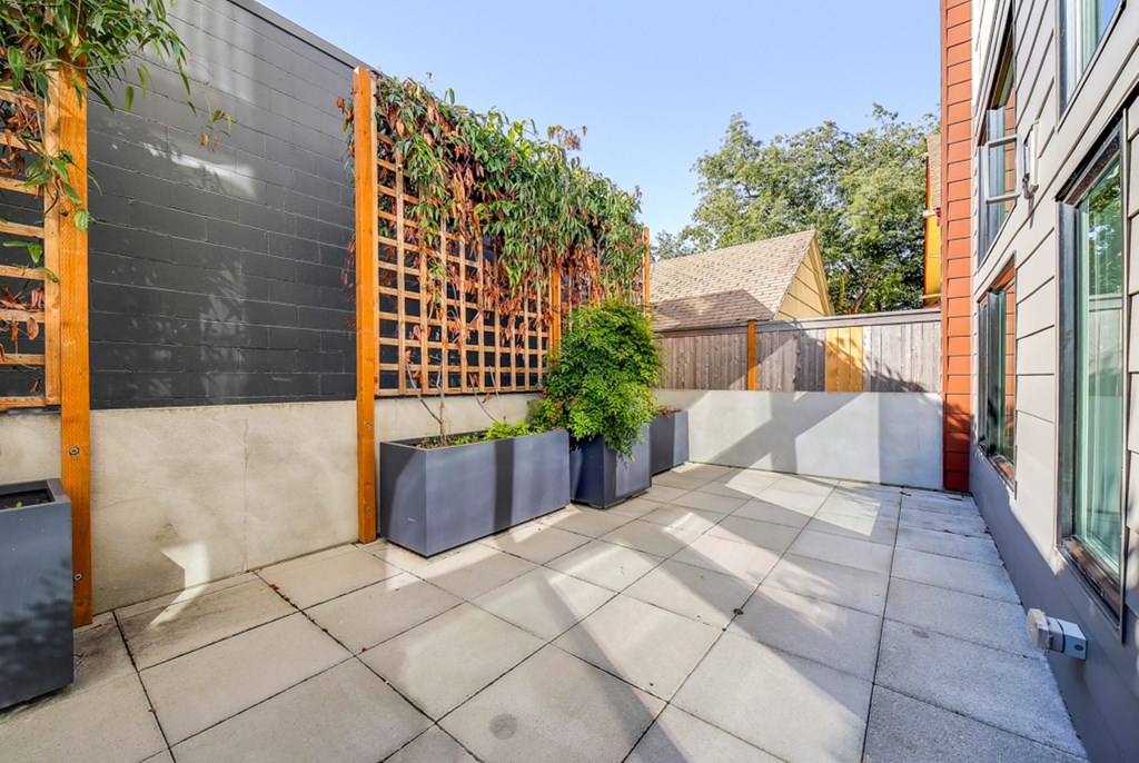 The Hayes on Stone Way Apartments small patio with a fence and plants