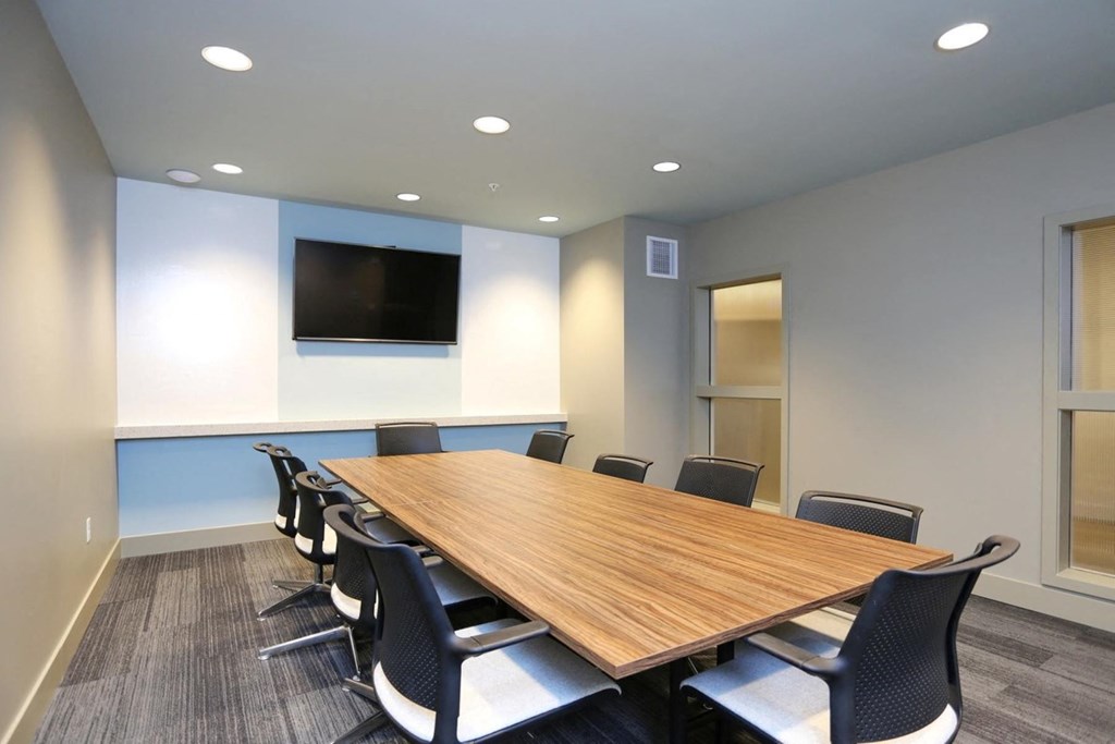 a conference room with a large wooden table and chairs