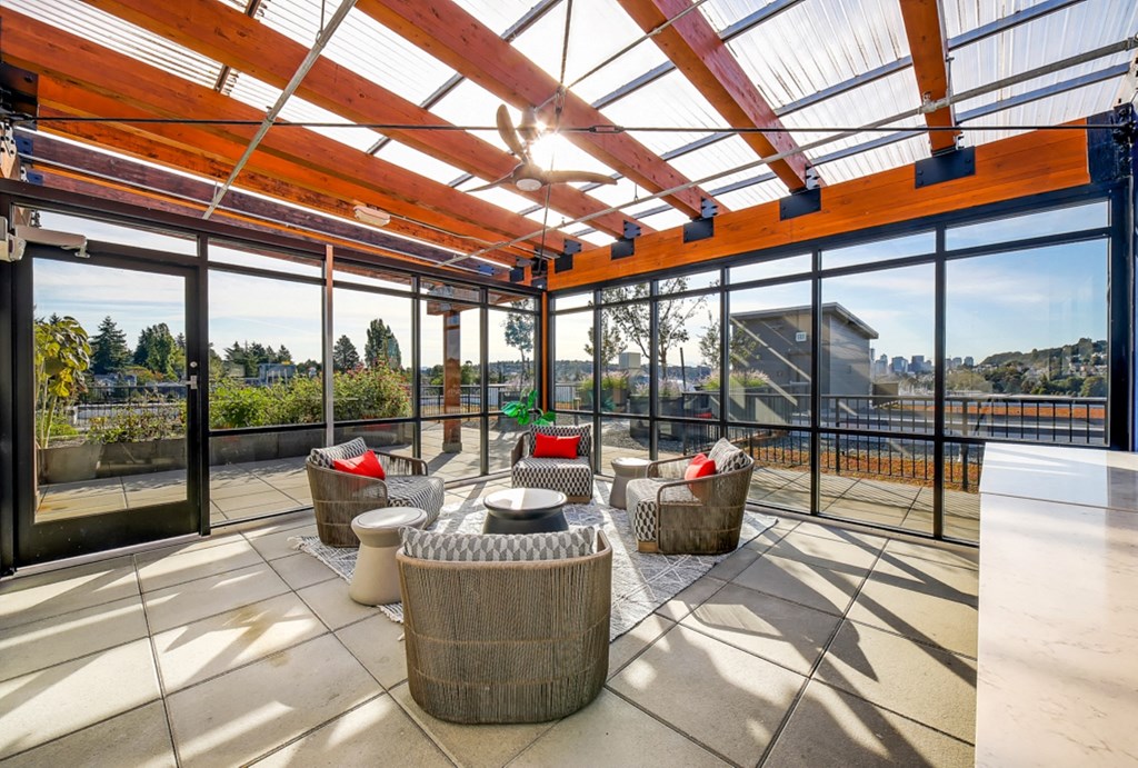 The Hayes on Stone Way Apartments patio with wicker chairs and a glass roof