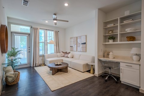 A living room with a white couch and a wooden coffee table.