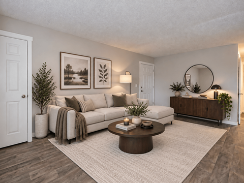 A living room with a white couch, a coffee table, and a potted plant.