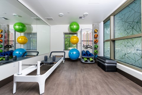 A gym with exercise balls and a rowing machine.