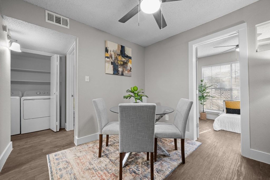A dining room with a table and chairs.