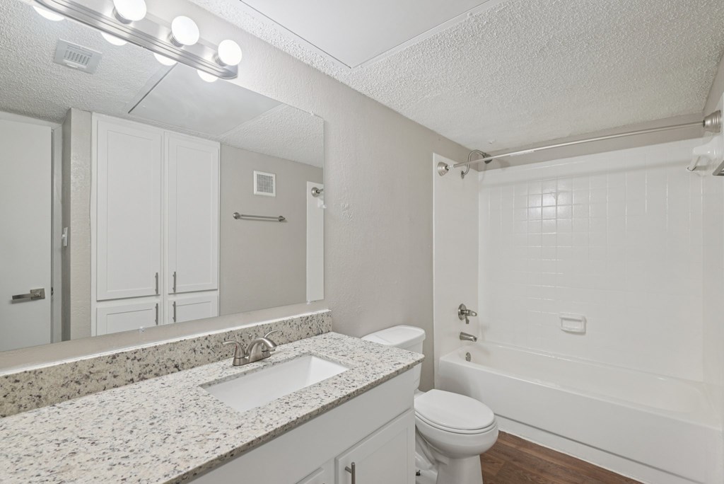 A white bathroom with a sink, toilet, and bathtub.