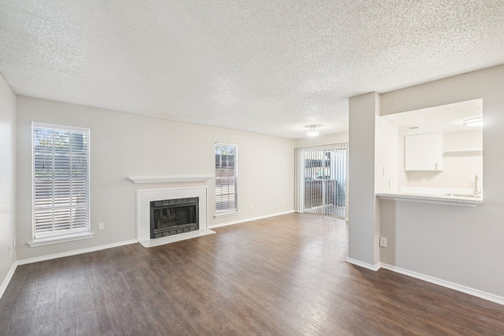 A living room with a fireplace and wood flooring.