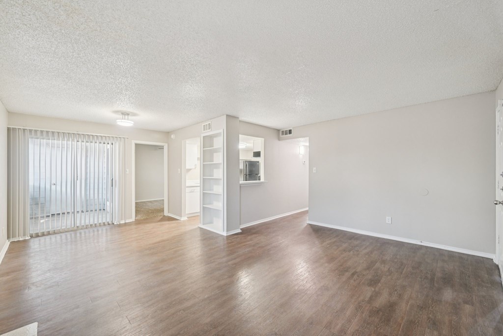 A large empty room with wooden floors and white walls.