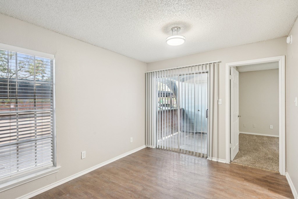 A room with a sliding glass door leading to a balcony.