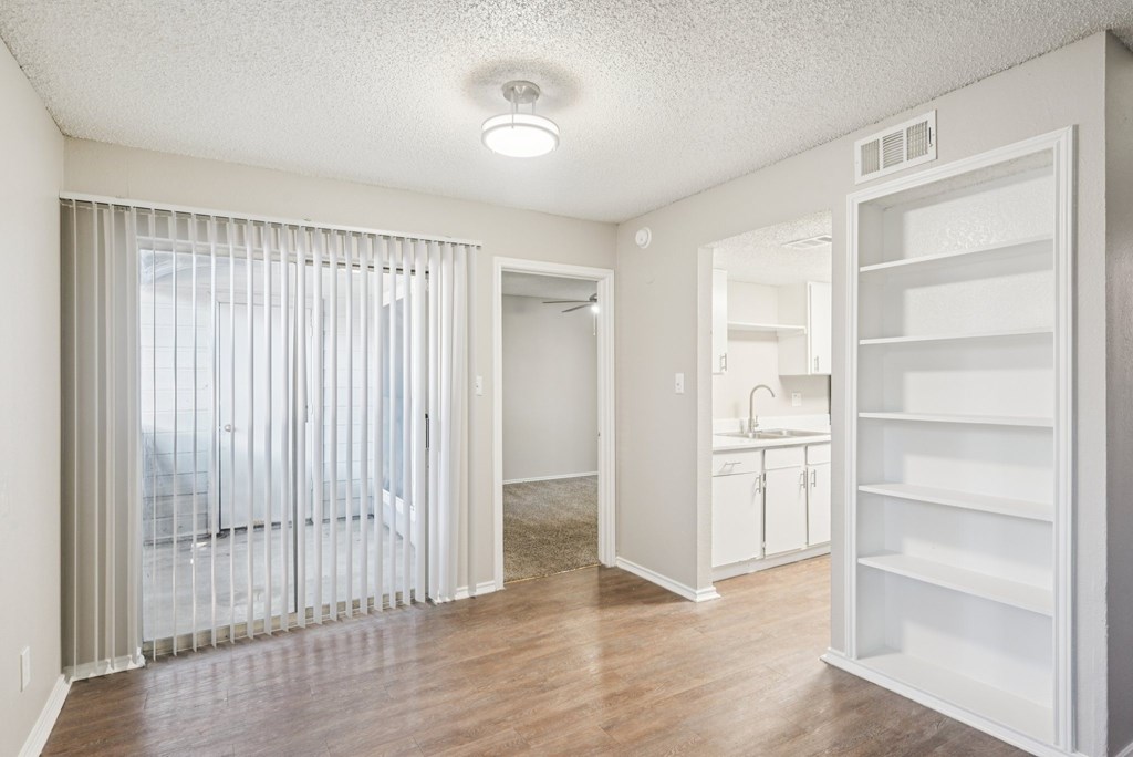 A white kitchen with a refrigerator and a sink.