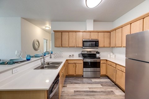 A kitchen with wooden cabinets and a stainless steel refrigerator.