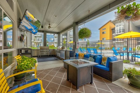 Outdoor lounge with grilling stations and pool access at The Northern at Coeur dAlene Place Apartments, Coeur dAlene