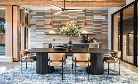 A modern dining room with a large table and chairs.