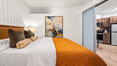 A bedroom with a large bed and a painting on the wall.