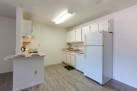 A kitchen with white appliances and cabinets.