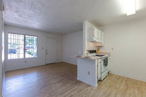 A kitchen with white cabinets and a wooden floor.