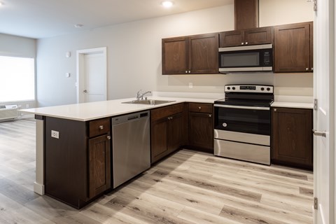 A kitchen with dark wood cabinets and a white counter.