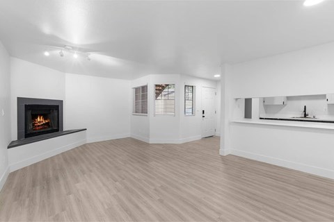 Spacious living room with a fireplace and wooden-style  flooring at The Rosewood Apartments in Vancouver, Washington.