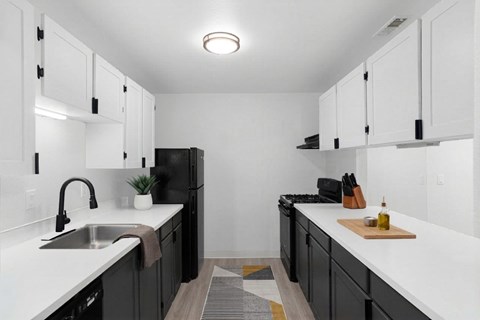 A kitchen with black cabinets and white countertops.