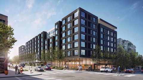 A modern multi-story building with a lot of windows is being constructed on a street corner.