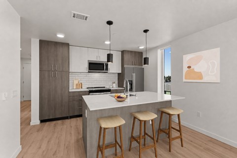 A kitchen with a bar stool in front of the counter.