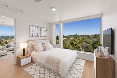 A bedroom with a large bed and a view of the city.