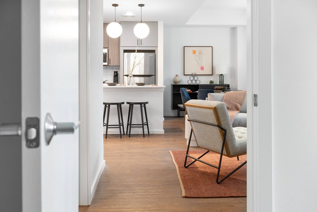 A modern living room with a bar stool and a chair.