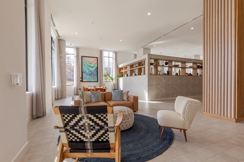A living room with a blue rug and a wooden chair.