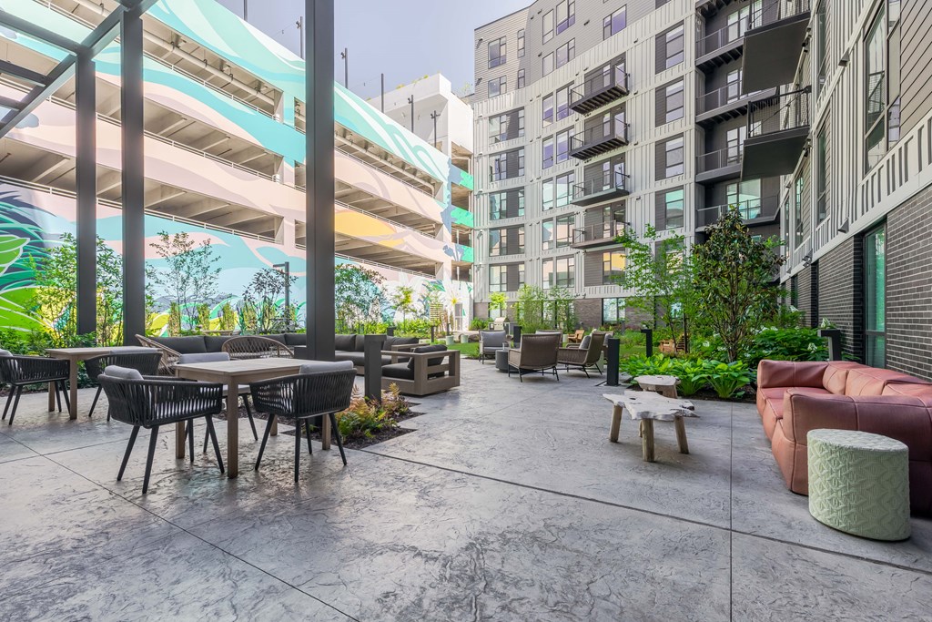A patio area with a table and chairs is surrounded by buildings.