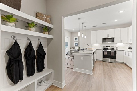 an open kitchen and living room with white cabinets