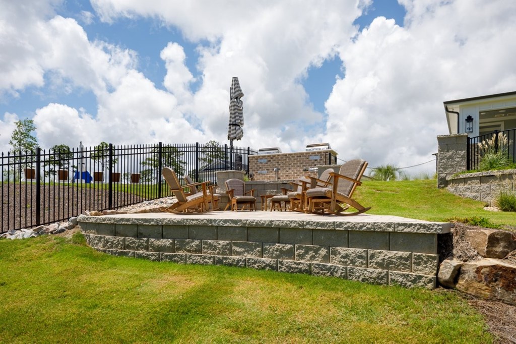 A patio with a table and chairs is surrounded by a stone wall.
