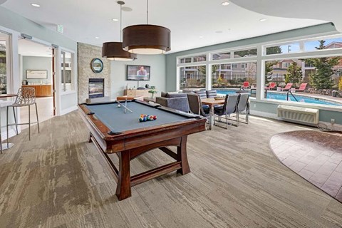 A billiard table is in the middle of a room with a pool table and a television.